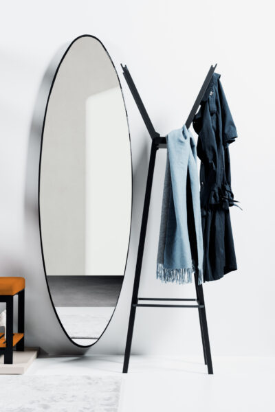 Ellipsenförmiger Spiegel und ein Kleiderständer